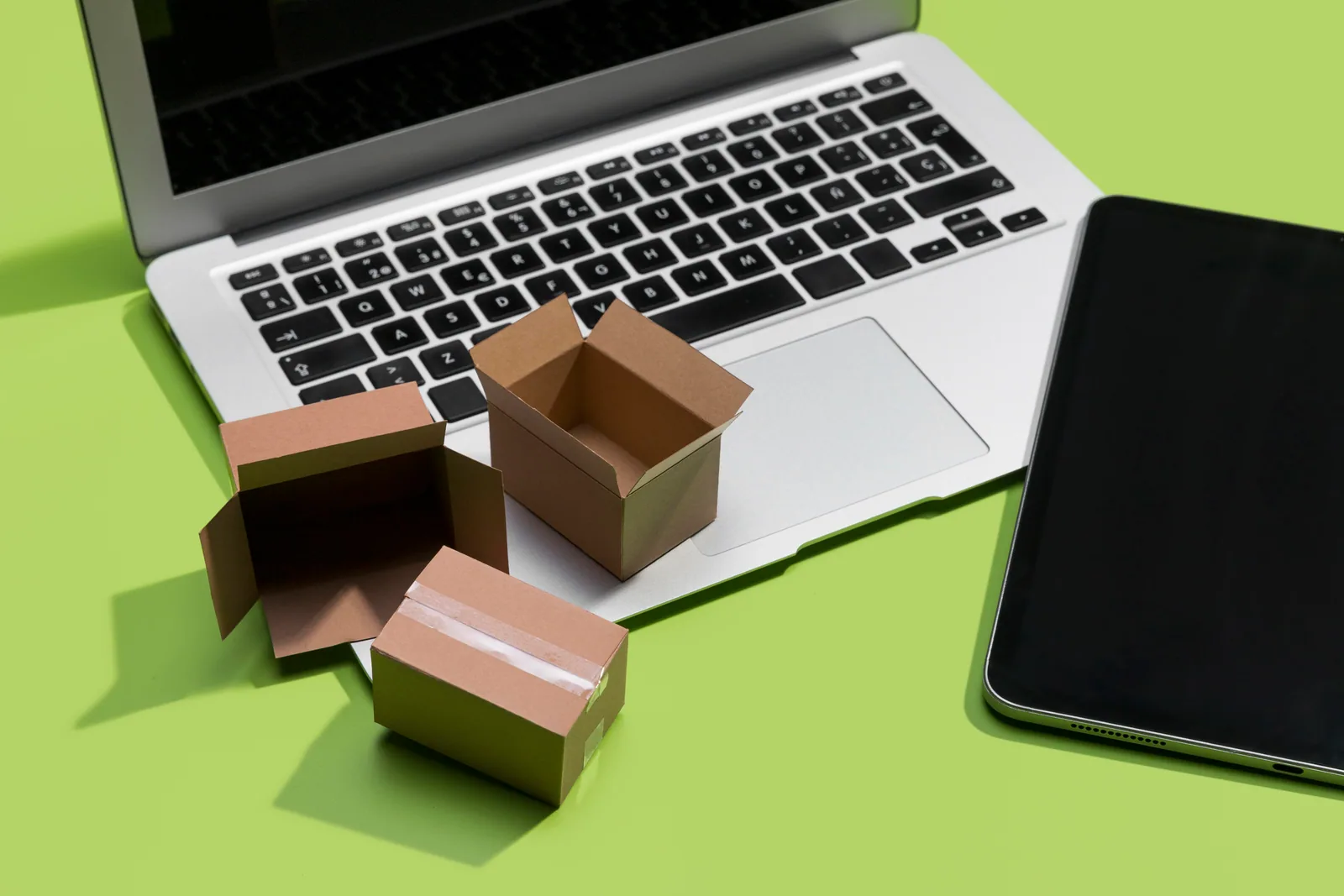 Small shipping boxes arranged beside a laptop and tablet